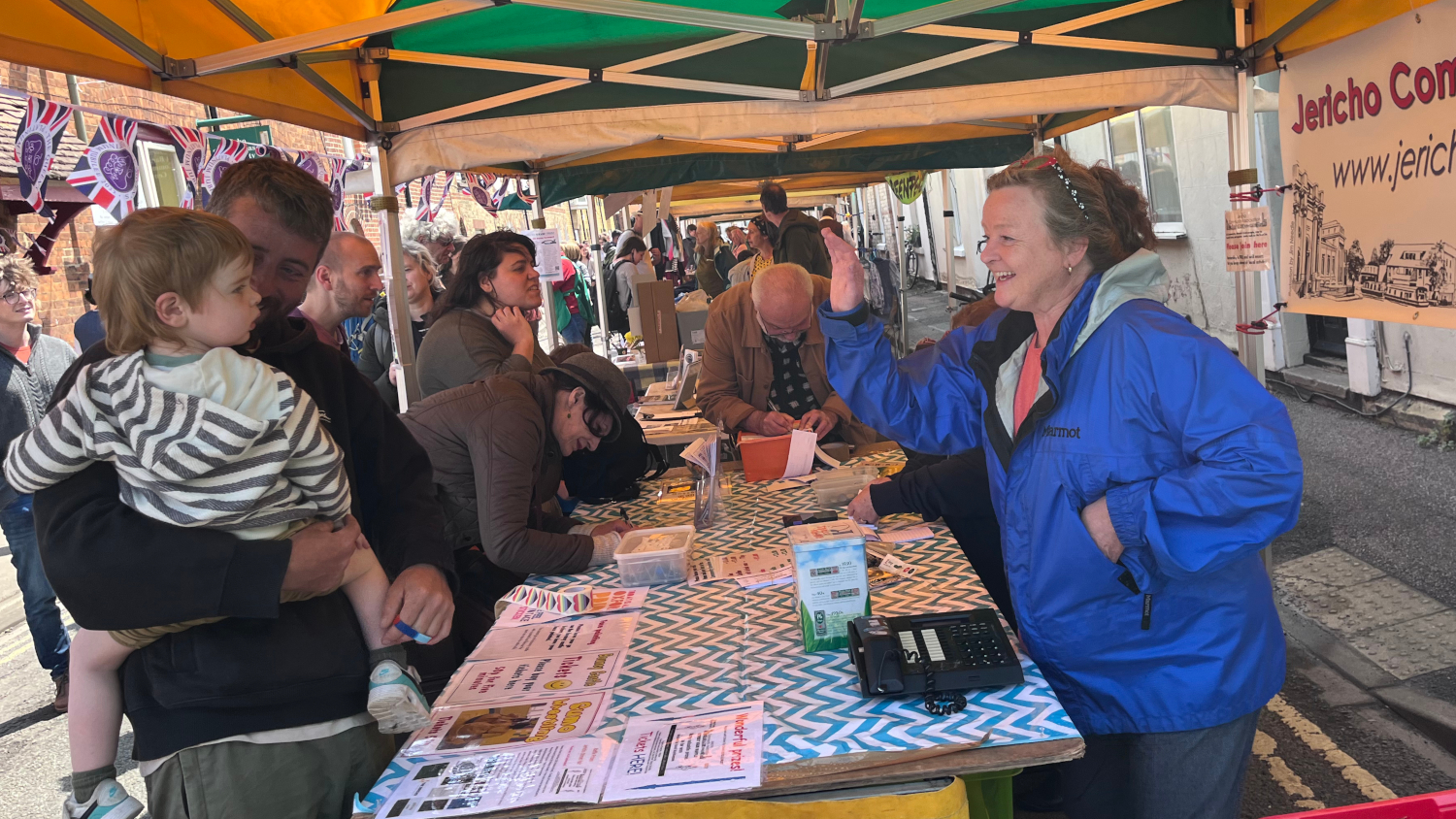 <p>Zoe Guy on the JCA stall greets her grandson.</p>