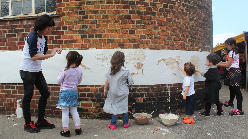 Chuey Uniz-Liu and friends work on a (sadly) temporary mural for the church.